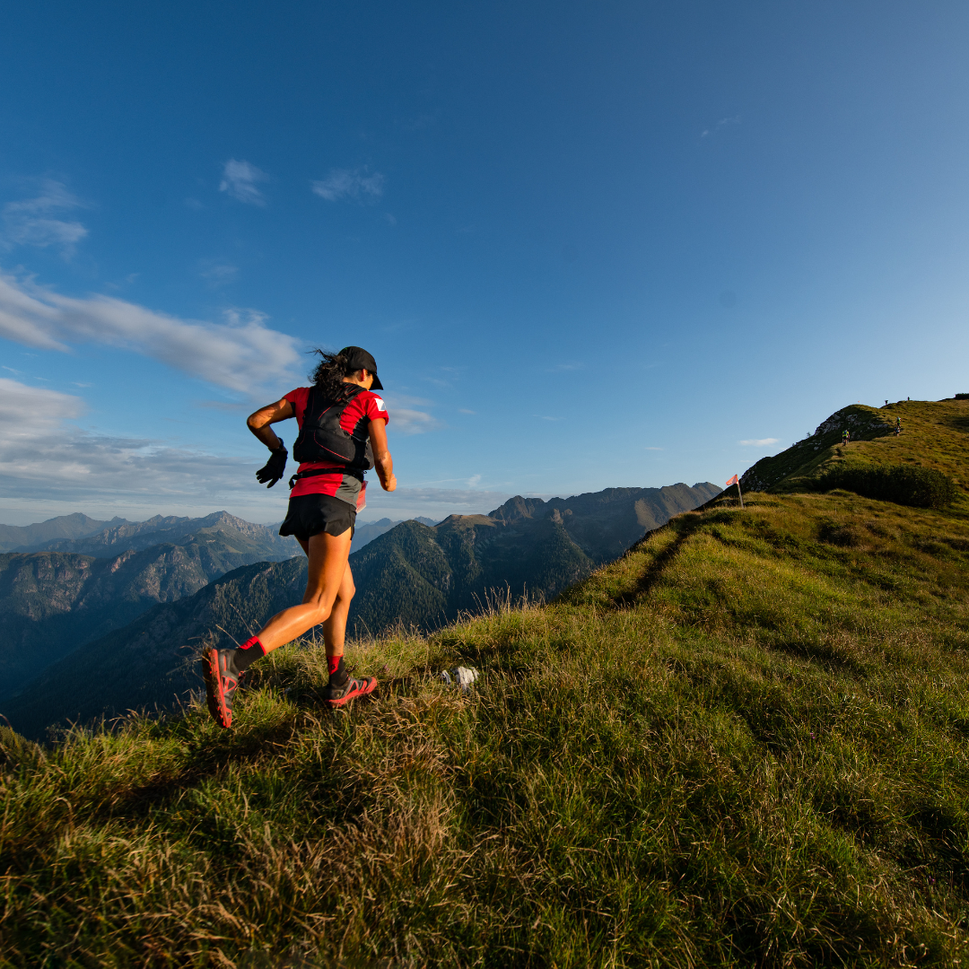 A woman running a mountain ridge.