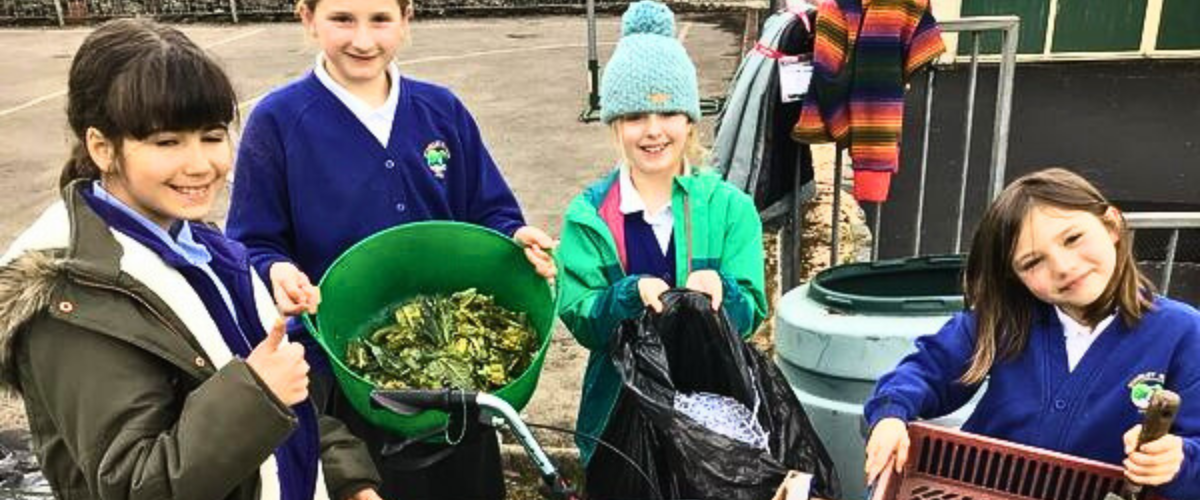 A group of children in a playground showing their composting process.